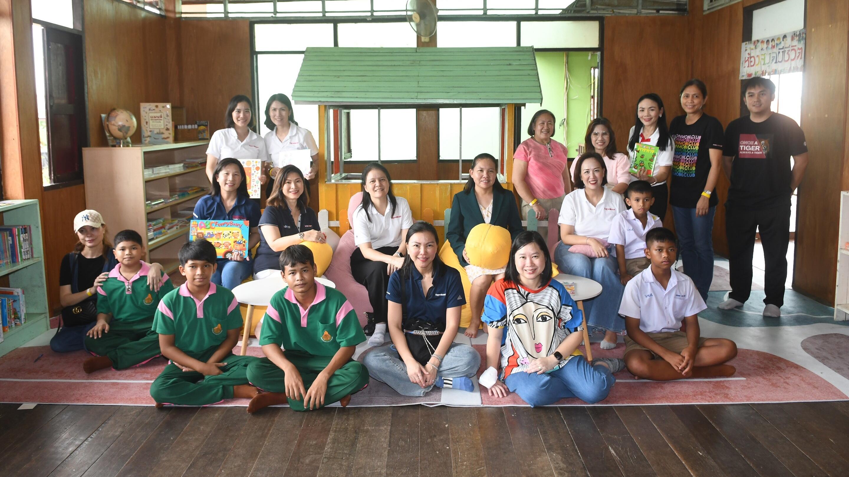 ExxonMobil management, school director, and students gathered at the newly revamped library corner.