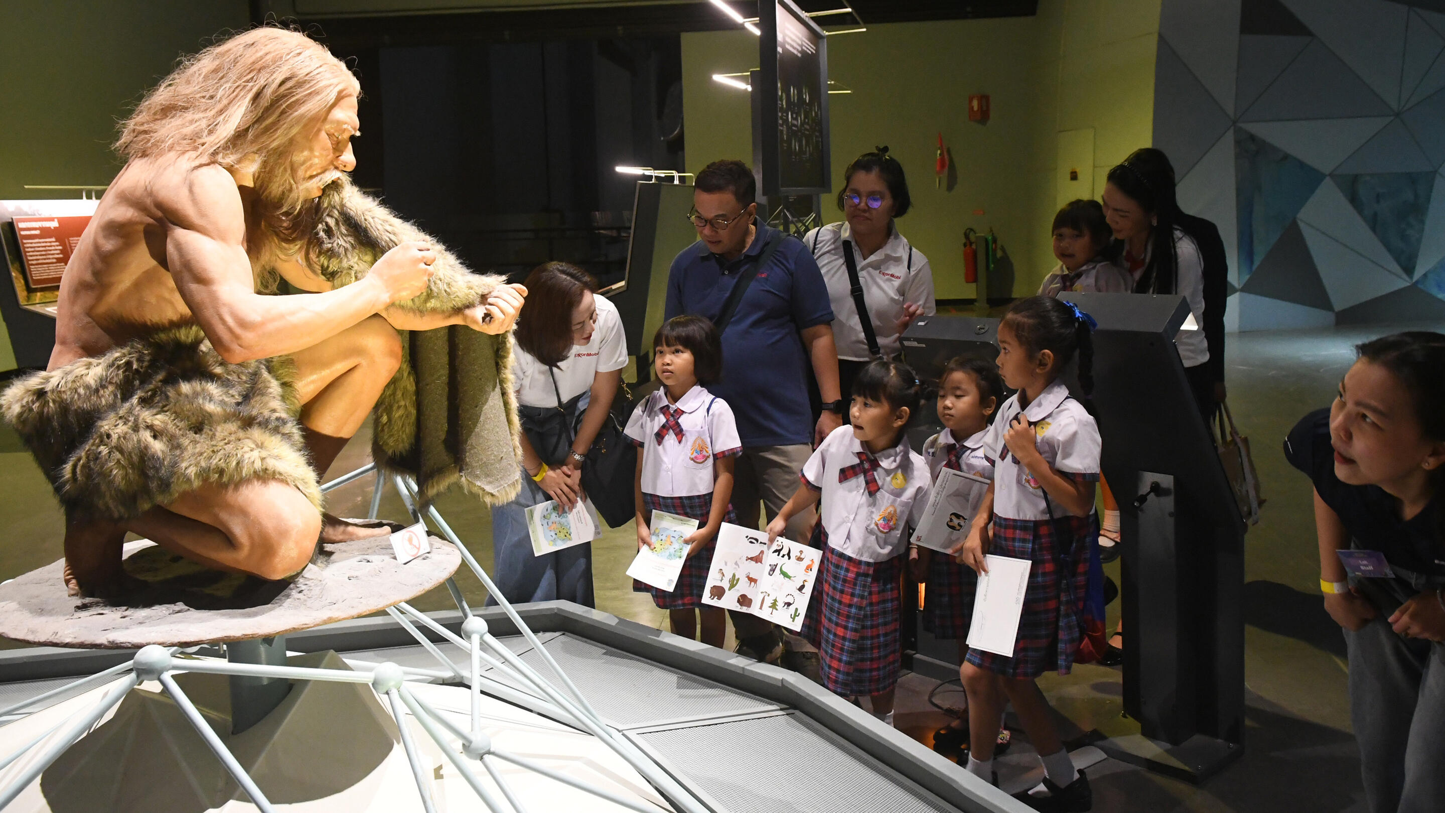 Employees taking students on a walk rally activity to explore the Rama IX Museum.