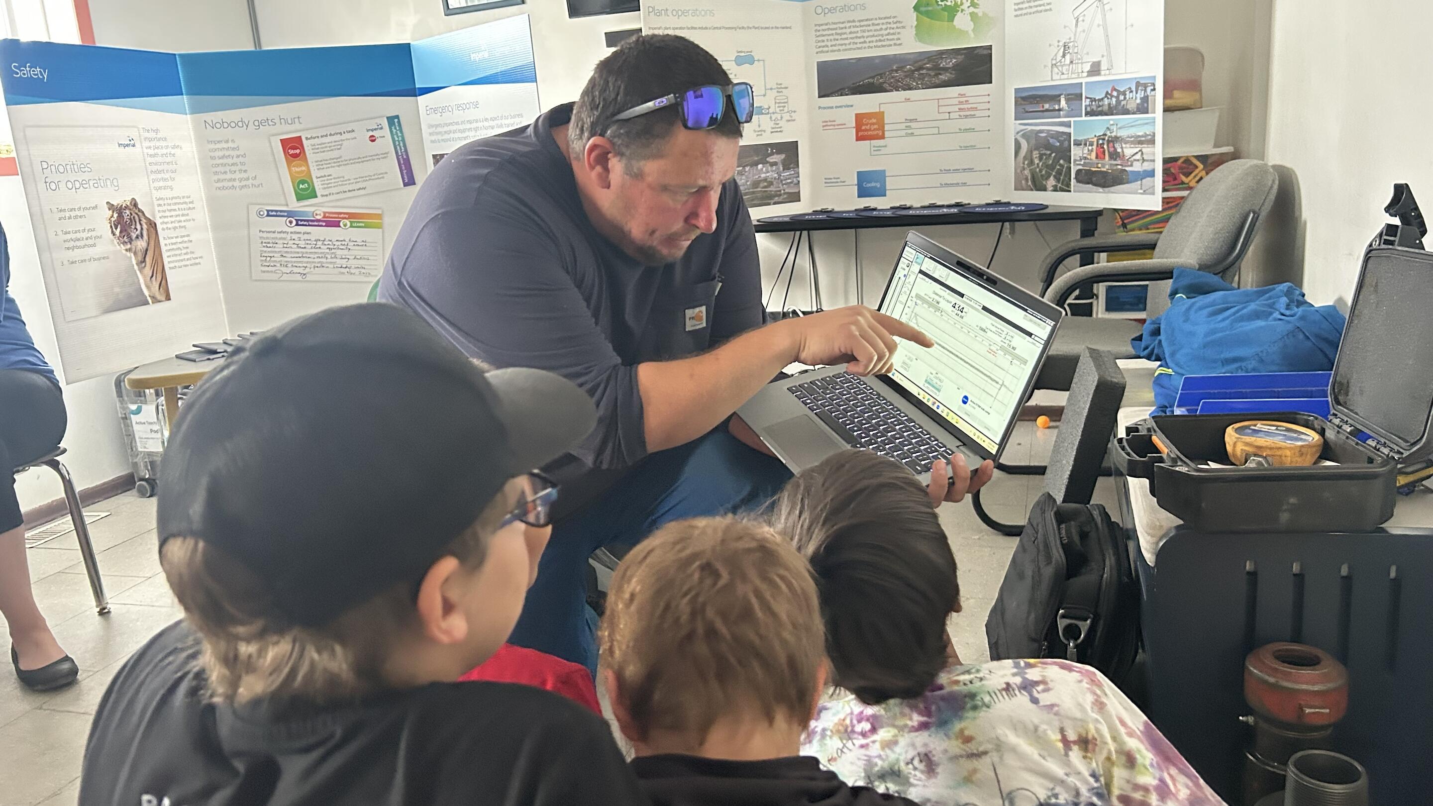 Dustin showing some field data on laptop sceen to 4 kids