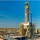 A modern oil drilling rig set up in a flat, open landscape under a clear blue sky.