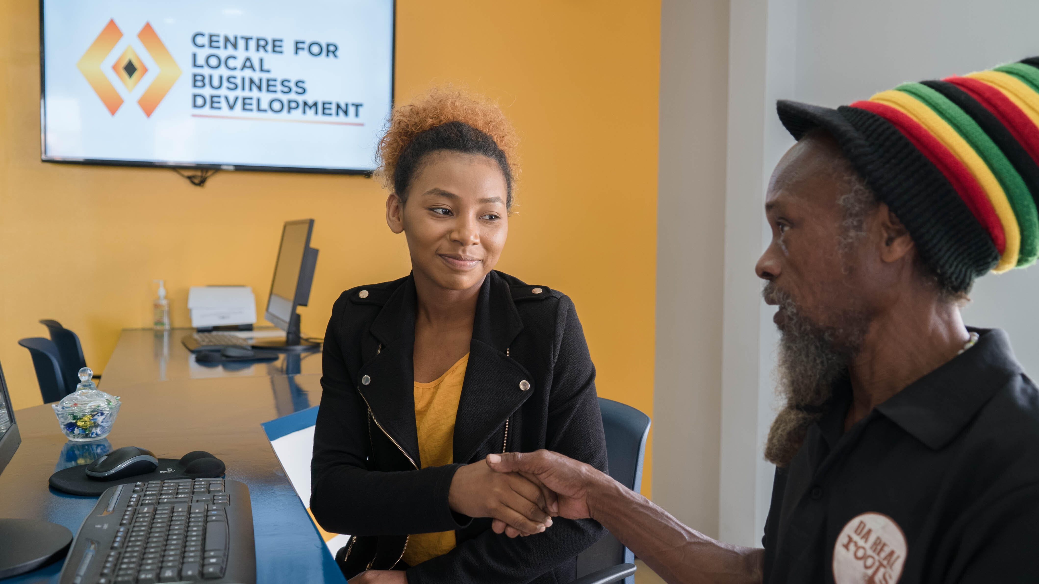 individuals shaking hands at Guyana's Center for Local Business Development