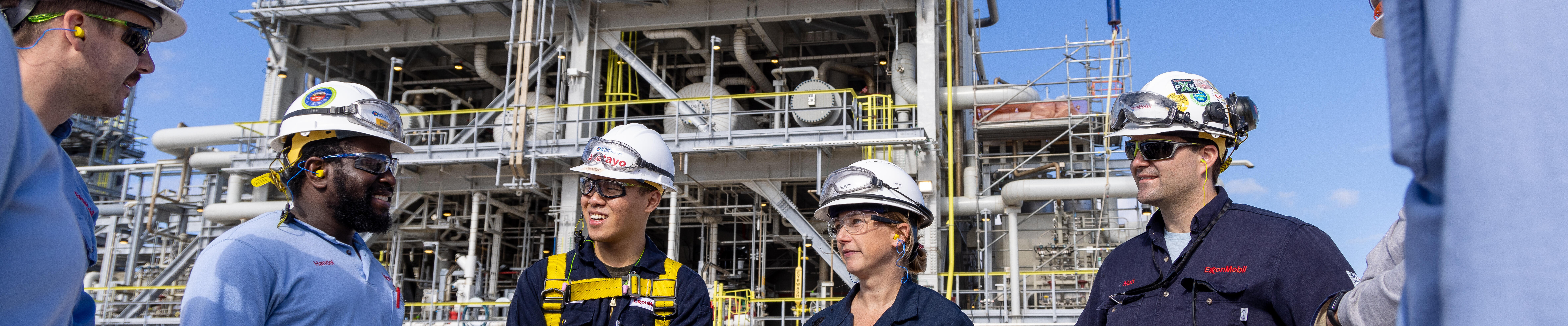 employees wearing personal protective gear at petrochemical facility having a discussion