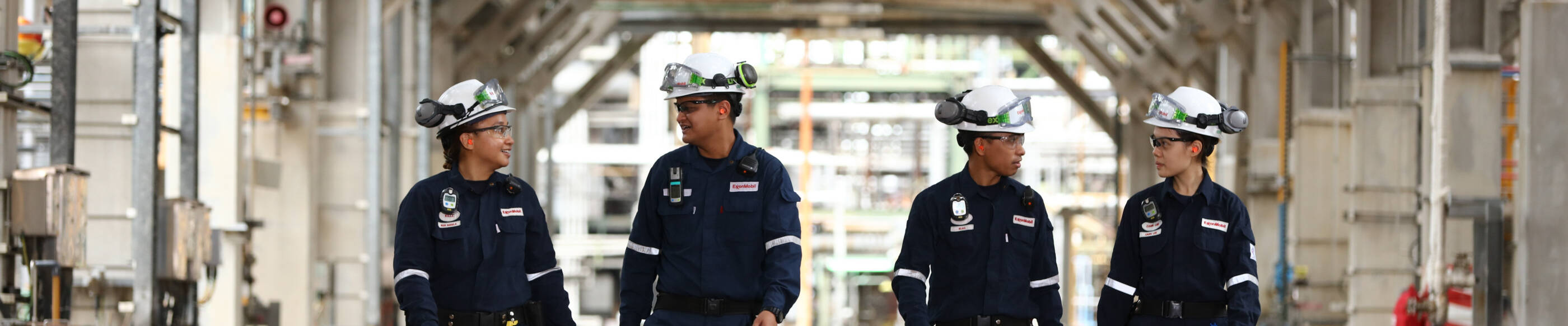 workers in safety apparel walking through a refinery