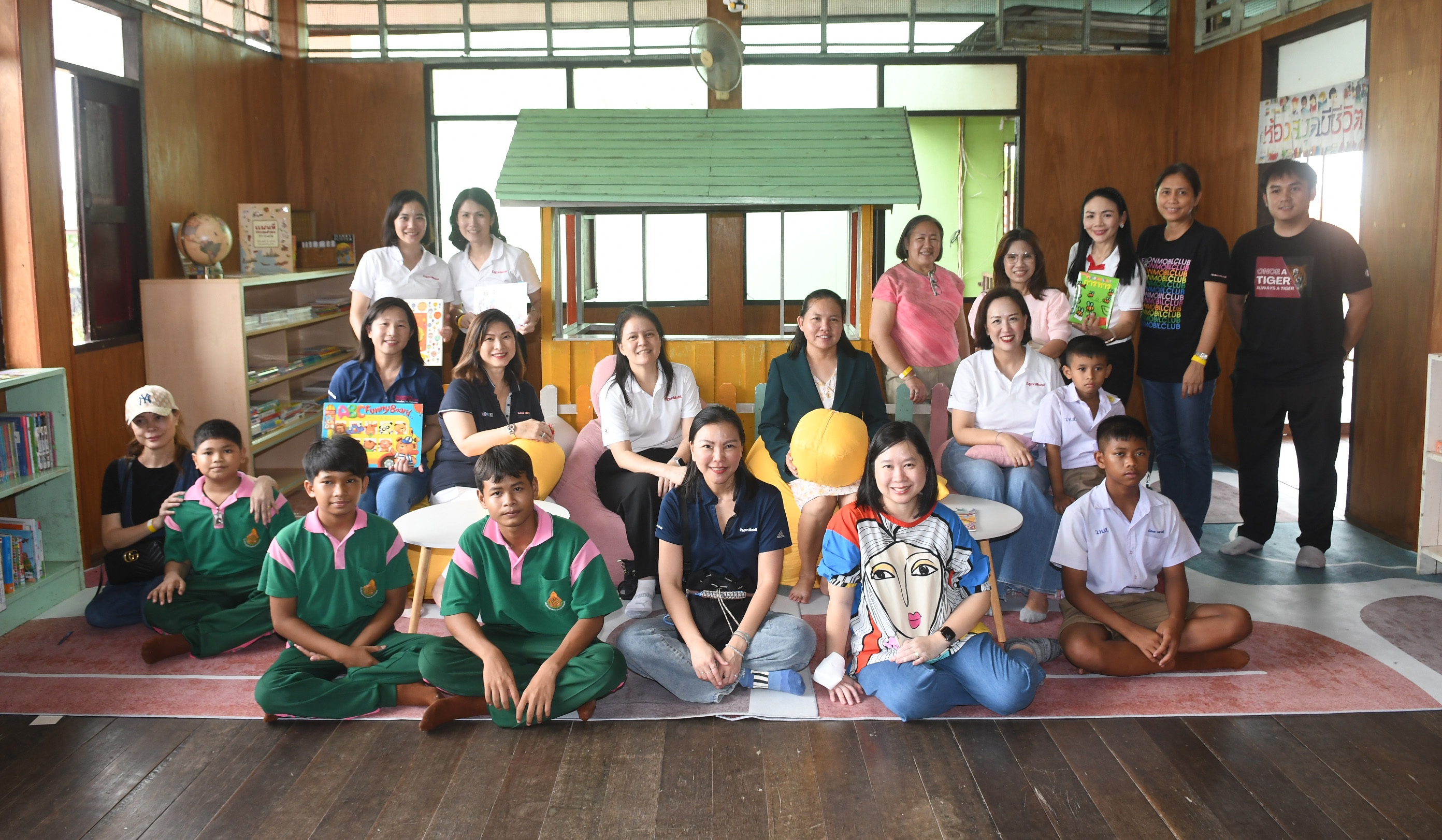 ExxonMobil management, school director, and students gathered at the newly revamped library corner.